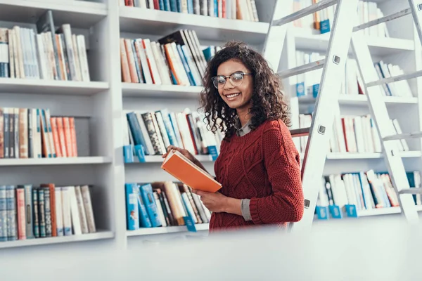 Taille hoch von hübscher Dame, die Buch hält und lächelt — Stockfoto