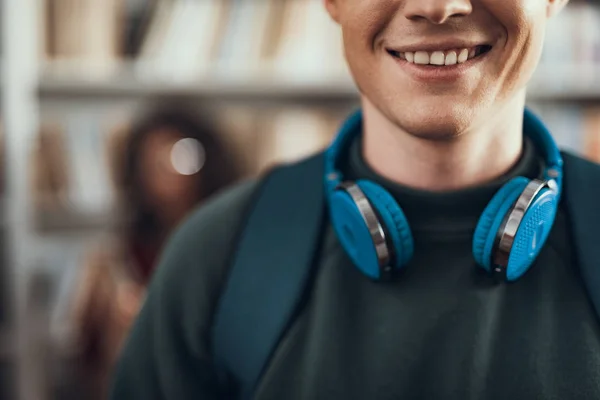 Gros plan d'un homme souriant debout avec un casque sur le cou — Photo