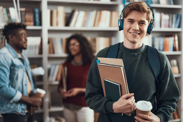 Fröhliche kaukasische Studentin hält eine Tasse Kaffee und genießt die Musik — Stockfoto