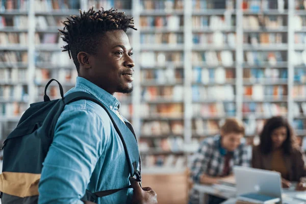 Estudante afro-americano alegre usando mochila e sorrindo — Fotografia de Stock