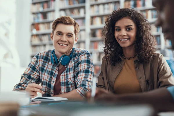 Freundliche junge Frau und ihr Freund lächeln und schauen — Stockfoto