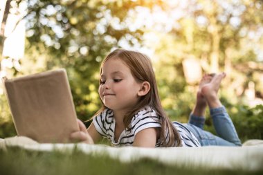 Kitap üzerinde park battaniyeye kızla