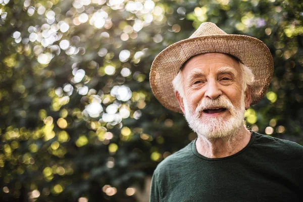 행복 한 오래 된 소박한 사람이 정원에서 서 — 스톡 사진