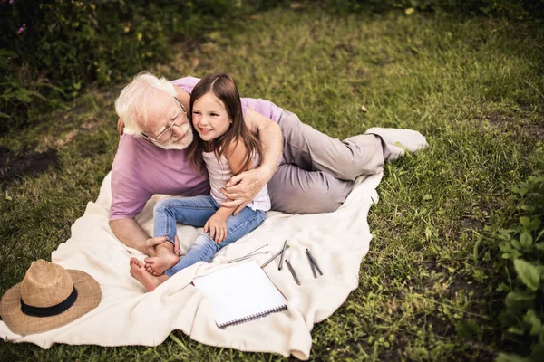 Viejo descansando con su graddaughter en el parque —  Fotos de Stock