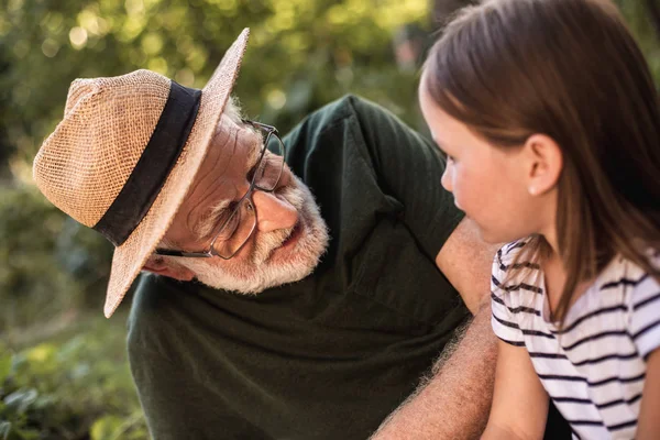 Menina bonita com seu avô em chapéu flaxen descansando no parque — Fotografia de Stock