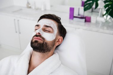 Adamın beyaz kil maskesi yüzünde yakın çekim