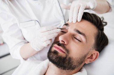 Koparma kaşları güzellik uzmanı, elinde cımbız