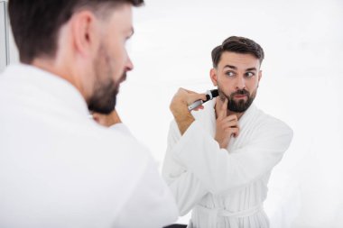 Dikkatli biri tıraş ederken yanağını dokunmadan
