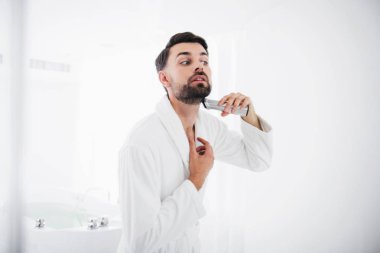 Adam dikkatle sakalını tıraş bornoz konsantre