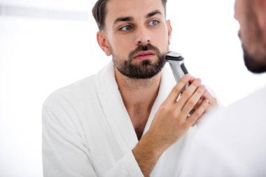 Onun sakalı tıraş makinesi kullanan ciddi adam, yakın çekim