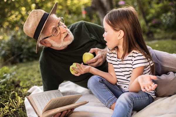 Дедушка с внучкой на пикнике — стоковое фото