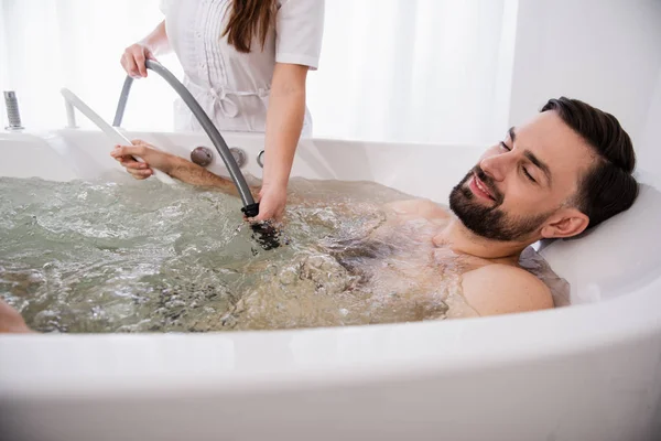 Bärtiger Mann entspannt sich in der Hydromassage-Badewanne und schließt die Augen — Stockfoto