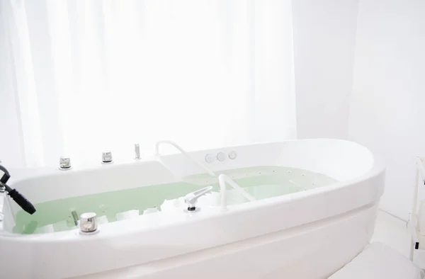 White room with hydro massage bath in it