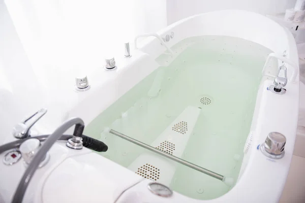 Hydro massage bath full of water in modern spa salon