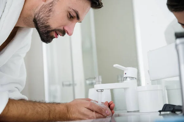 Hombre barbudo sosteniendo agua en sus manos ventosas —  Fotos de Stock