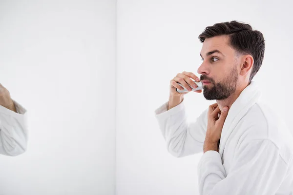 Serious man touching his neck while shaving beard — Φωτογραφία Αρχείου