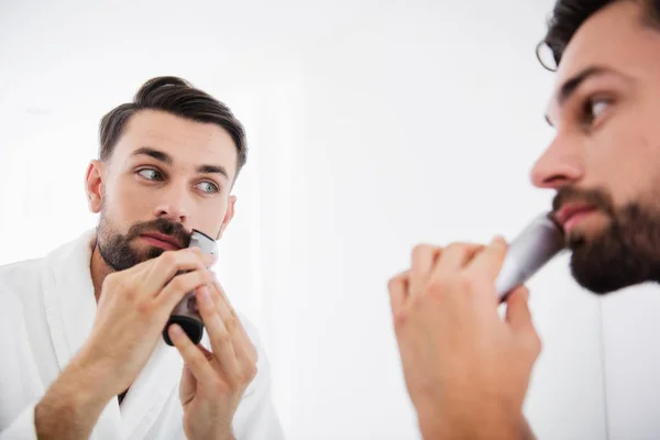 Primer plano del hombre con cuidado utilizando la máquina de afeitar — Foto de Stock