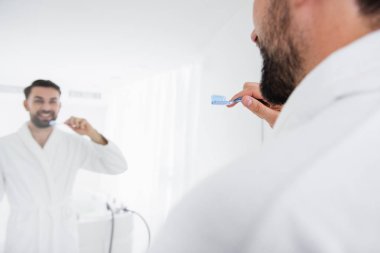 Dişlerini fırçalıyor adam ayna yansıması