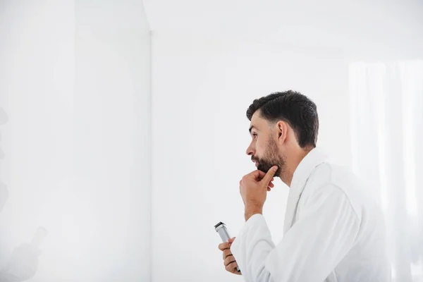 Primer plano del hombre reflexivo mirando su barba en el espejo — Foto de Stock