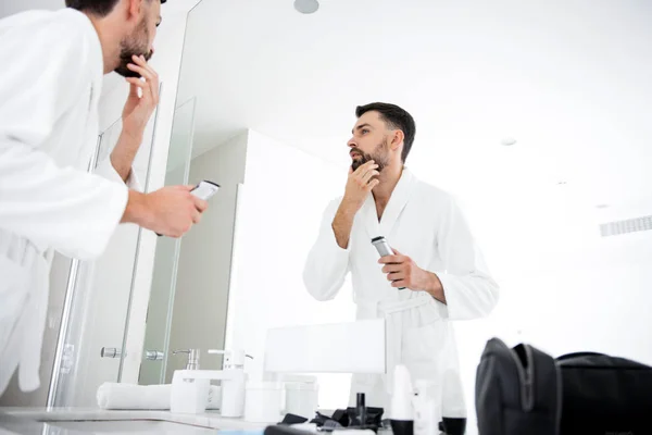 Homem calmo tocando sua barba na frente do banheiro — Fotografia de Stock