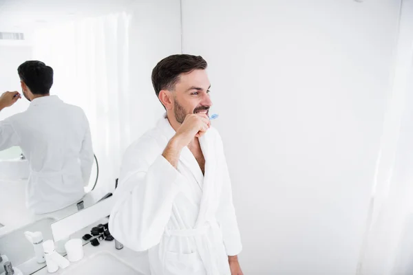 Cintura hacia arriba del hombre feliz cepillándose los dientes y sonriendo — Foto de Stock