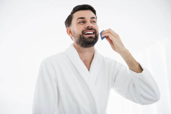 Close up van gelukkig man glimlachend en kammen van de baard — Stockfoto