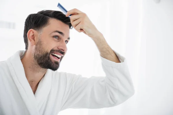 Close up de homem barbudo feliz sorrindo e pentear o cabelo — Fotografia de Stock