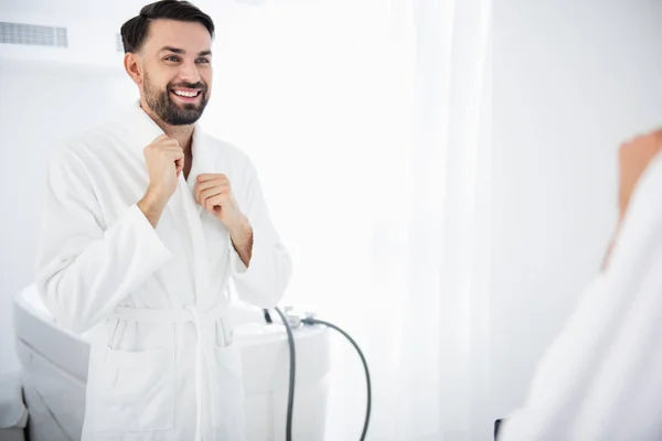 Homem emocional olhando feliz enquanto de pé em roupão de banho — Fotografia de Stock
