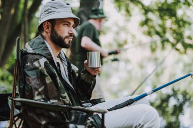Hoş adam Balık tutma sırasında ferahlatıcı içki içme