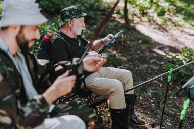 Yaşlı adam yemi oltaya Balık tutma sırasında koyarak