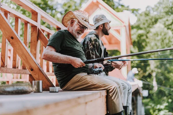 Positive aged man fishing on the weekend — Stock Photo, Image