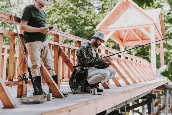 Starší muž a jeho syn stojící na dřevěný most — Stock fotografie