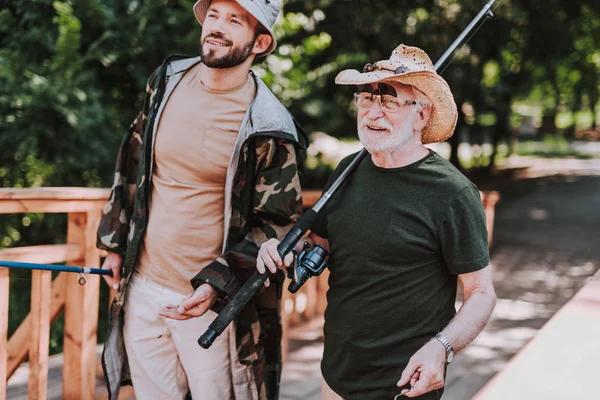 Waist up of a positive elderly angler with his son — Stock Photo, Image