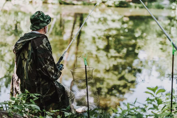 Vista trasera de un agradable pescador disfrutando de su hobby — Foto de Stock