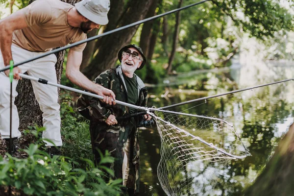Radostné postarší rybář těší víkend s jeho synem — Stock fotografie