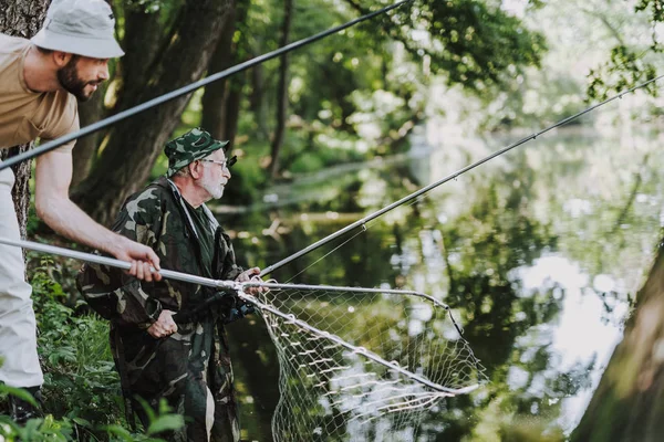 Profesionální důchodce rybář loví s jeho synem — Stock fotografie