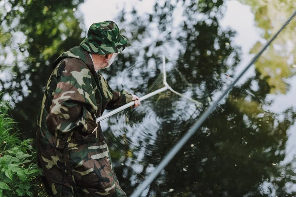 Pescador idoso profissional usando rede para a pesca — Fotografia de Stock