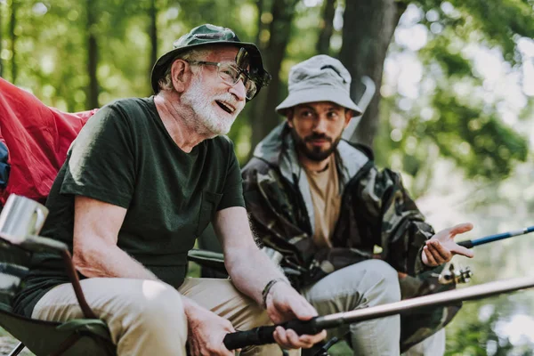 Joyful aged man fishing with his son together — Stock Photo, Image