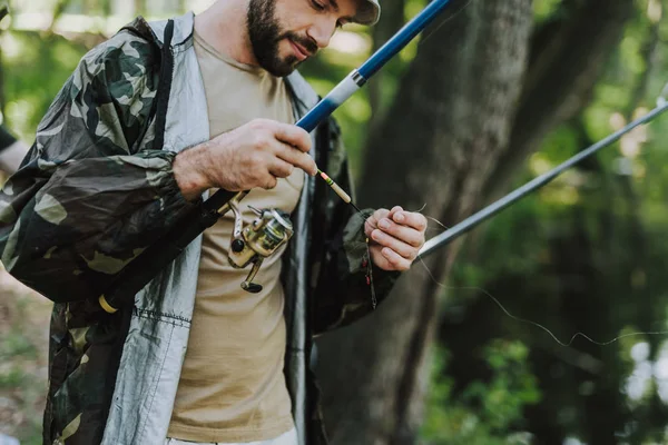 Homem barbudo agradável fixando o gancho de sua vara — Fotografia de Stock