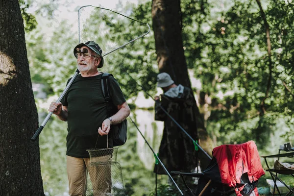 Profesyonel balık tutmak için ekipmanlar tutan olumlu erkek fisher — Stok fotoğraf