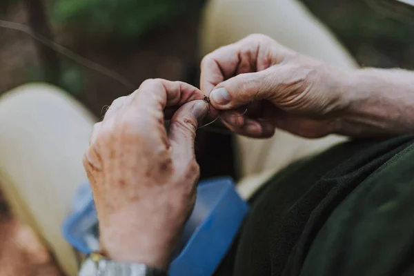 Close up of male hands fixing rod hook — Stock Photo, Image