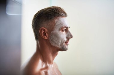 Yüz maskesi ayakta beyaz arka plan ile yakışıklı genç