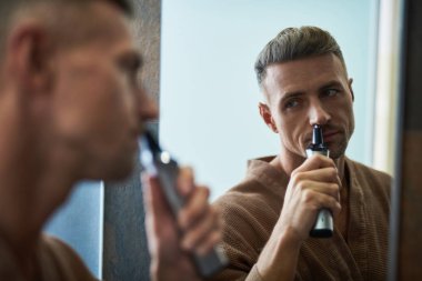 Yakışıklı genç adam ev banyo burun saç kaldırılıyor