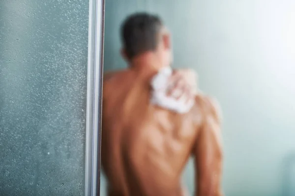 Douche deur met jonge man zichzelf wassen op onscherpe achtergrond — Stockfoto