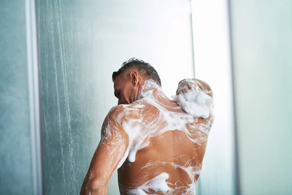 Naakte gentleman met schuim op zijn lichaam nemen douche thuis — Stockfoto