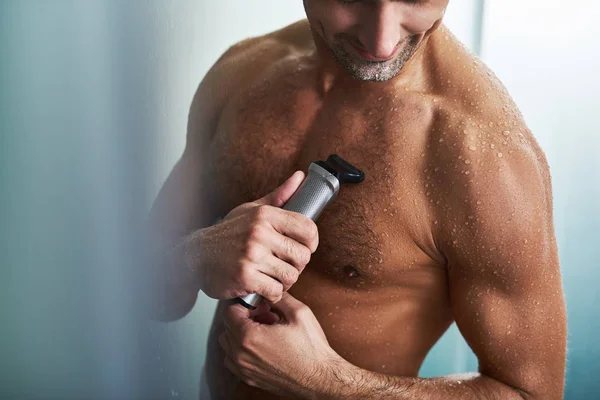 Young gentleman with muscular wet body shaving chest after shower — Stock Photo, Image