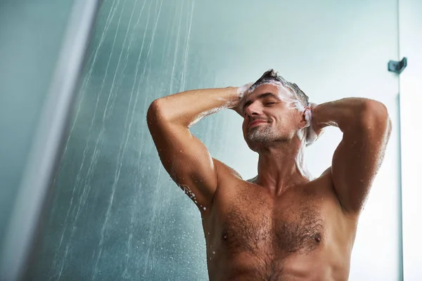 Knappe jongeman met mooie lichaam wassen van zijn haren — Stockfoto