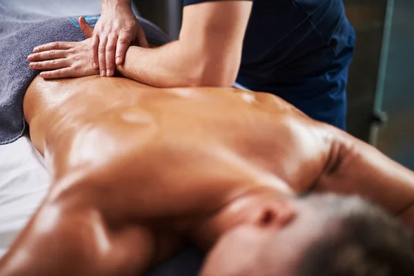 Ung man mottagande professional tillbaka massage på spasalong — Stockfoto