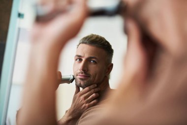 Yakışıklı adam aynaya bakıyorum ve gülümseyen tıraş