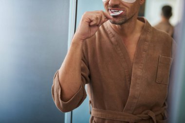 Banyo, diş fırçalama bornoz genç tıraşsız adam